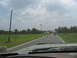 1995 Ford C-350 (Centurion Conversions) - Driving down a country road with fields and trees lining the asphalt.