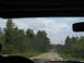 1995 Ford C-350 (Centurion Conversions) - Driving down a country road with trees lining both sides and a cloudy sky overhead.