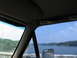 1995 Ford C-350 (Centurion Conversions) - Driving over a bridge with a view of a lake and tree-lined shores on a sunny day.