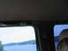 1995 Ford C-350 (Centurion Conversions) - Looking out from inside a vehicle at a lake scene with trees and boats.