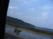 1995 Ford C-350 (Centurion Conversions) - Driving over a bridge with a scenic view of water and hills under a blue sky with clouds.