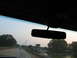 1995 Ford C-350 (Centurion Conversions) - Driving on a highway at dusk with trees lining the road and a distant vehicle ahead.