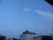 1995 Ford C-350 (Centurion Conversions) - View through a windshield shows reflections of buildings and sky, with a tall antenna visible.