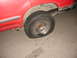 1992 Ford Explorer - The rear passenger side tire on this red vehicle is completely flat.