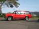 1992 Ford Explorer - Side view of a red 1992 Ford Explorer parked in a lot under a tree.