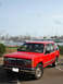 1992 Ford Explorer - A red 1992 Ford Explorer is parked near a marina filled with sailboats.
