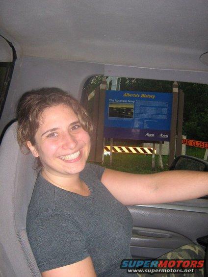 Woman smiles from inside a vehicle, with a historical marker visible outside