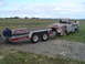1955 Ford F-100 - A weathered pickup truck is being loaded onto a U-Haul trailer, suggesting a move or transport for restoration.