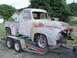 1955 Ford F-100 - This 1955 Ford F-100 pickup truck is being transported on a U-Haul trailer, displaying significant rust and missing its front grille.