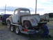 1955 Ford F-100 - A rusty 1955 Ford F-100 pickup truck is loaded onto a trailer, with a blue SUV in the background.