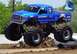 1996 Ford Bronco - A blue Bigfoot monster truck is airborne over a crushed car, with a Ford flag in the background.