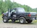 1990 Ford Bronco - 1990 Ford Bronco with soft top and open driver's door, parked off-road.