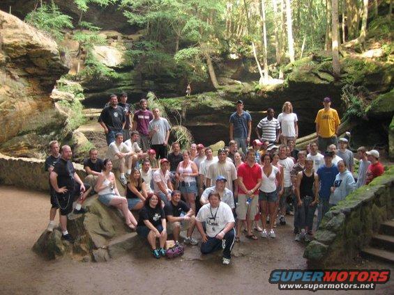 Group of people posing for a photo in a wooded area with rock formations