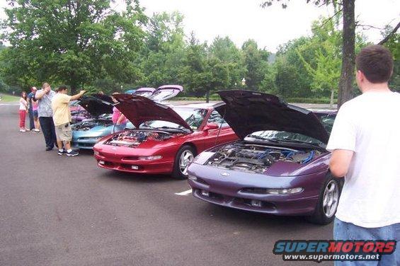 Purple 1995 Ford Probe with hood open, parked in a line with other cars