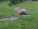 1990 Ford Bronco - Ford Econoline van navigating a challenging muddy off-road path.