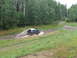 1990 Ford Bronco - A Ford Bronco navigates a wet and muddy off-road path, kicking up water as it goes.