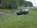 1990 Ford Bronco - A 1990 Ford Bronco navigates a muddy off-road course surrounded by trees and greenery.
