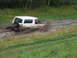 1990 Ford Bronco - This Ford Bronco is struggling to get through a muddy track, with water and mud splashing everywhere.