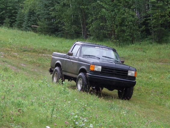 Black 1990s pickup truck driving off-road
