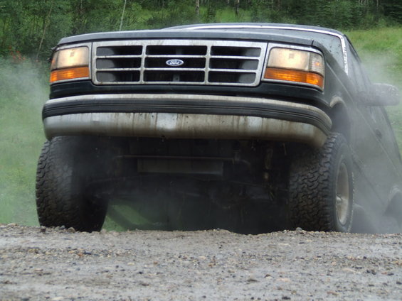 1990 Ford Bronco front view, driving on a dirt road