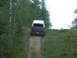 1990 Ford Bronco - A Ford Bronco navigates a steep, wooded dirt path.