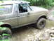 1990 Ford Bronco - This Ford Bronco is covered in mud as it drives through a rocky stream.