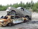 1990 Ford Bronco - A 1992 Ford Bronco is parked on top of a severely damaged and rusted sedan in a junkyard.