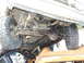 1990 Ford Bronco - Undercarriage of a vehicle is visible, resting on another damaged vehicle.