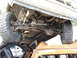 1990 Ford Bronco - The undercarriage of a vehicle is visible, with its tires resting on the roof of a damaged car.