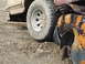 1990 Ford Bronco - Close-up of a heavily damaged and rusted vehicle fender next to a large off-road tire.