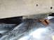 1990 Ford Bronco - Close-up view of the corroded undercarriage of a vehicle, revealing significant rust and wear.