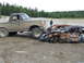 1990 Ford Bronco - A muddy 1990 Ford Bronco is parked next to a heavily damaged and rusted car in an outdoor setting.