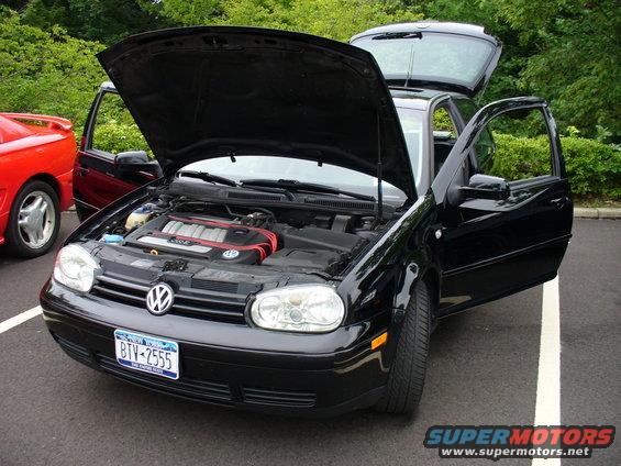 Black Volkswagen Golf GTI with hood and doors open, front view. New York license plate BTV-2555