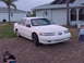1994 Ford Taurus - A white 1994 Ford Taurus sedan is parked in front of a house with two children nearby.