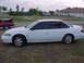 1994 Ford Taurus - Side view of a white 1994 Ford Taurus parked on grass with another car in the background.
