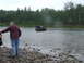 1990 Ford Bronco - A Ford Bronco navigates a shallow river crossing with a wooded bank in the background.