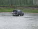 1990 Ford Bronco - A Ford Bronco navigates a river, its rear end visible as it drives through the water.