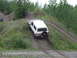 1990 Ford Bronco - A 1990 Ford Bronco navigates a steep dirt incline, with a person observing from a nearby mound of gravel.