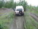 1990 Ford Bronco - White 1990 Ford Bronco navigates a steep dirt incline, spare tire mounted on the rear door.