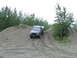 1990 Ford Bronco - A black 1990 Ford Bronco navigates a steep gravel incline amidst trees.