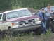 1990 Ford Bronco - A maroon and white Ford Bronco is parked off-road with two men standing nearby.