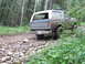 1990 Ford Bronco - Ford Bronco navigating a rough, rocky path through a dense forest.