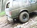 1990 Ford Bronco - Mud-splattered 1990 Ford Bronco navigates a rocky, off-road trail.