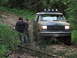 1990 Ford Bronco - Ford Bronco navigating a rough, forested path with two observers present.