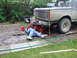1990 Ford Bronco - A person works on the rear of a gray Ford Bronco in a yard.