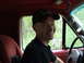 1990 Ford Bronco - Man smiles from the interior of a vehicle, with trees visible through the window.