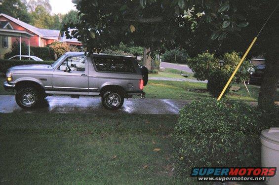 1995 Ford Bronco parked on wet driveway, side view