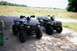 1995 Ford Bronco - Two ATVs are parked on a concrete driveway in front of a field.