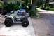 1995 Ford Bronco - A green Polaris Sportsman 4x4 ATV is parked on a concrete pad next to a gravel driveway.
