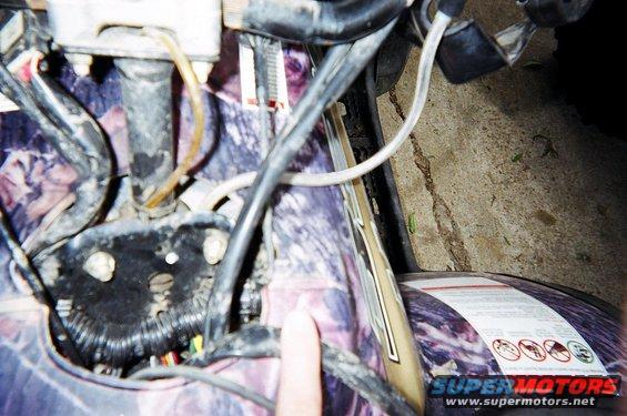 Close-up of ATV wiring and purple camouflage body panel with warning labels
